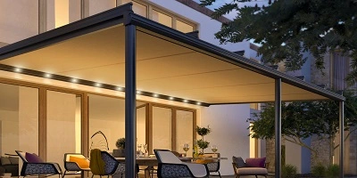 Avondzicht van een terras met serrezonwering Avondzicht van een terras met serrezonwering