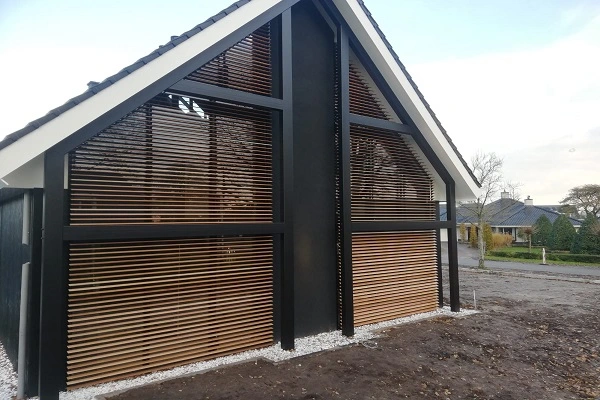 Constructie met grote vensters en houten lamellen die als zonwering dienen Constructie met grote vensters en houten lamellen die als zonwering dienen