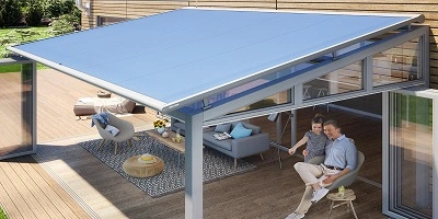 Houten terras onder serrezonwering waar familie zit Houten terras onder serrezonwering waar familie zit