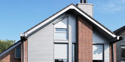 Huis met rolluiken op de ramen onder een schuindak Huis met rolluiken op de ramen onder een schuindak