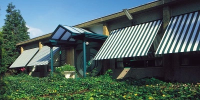 Huis met uitvalschermen aan de ramen, omgeven door groen Huis met uitvalschermen aan de ramen, omgeven door groen