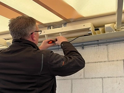 Installatie van een zonnescherm monteur past zonwering aan Installatie van een zonnescherm monteur past zonwering aan