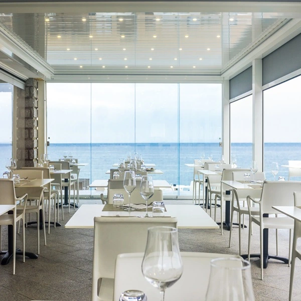 Hotel glazenwanden in lamellen overkapping