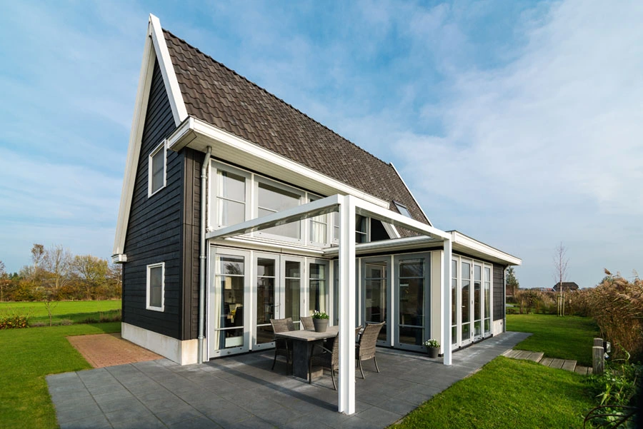 Qbus overkapping aangebouwd aan een modern huis met zwarte houten gevel