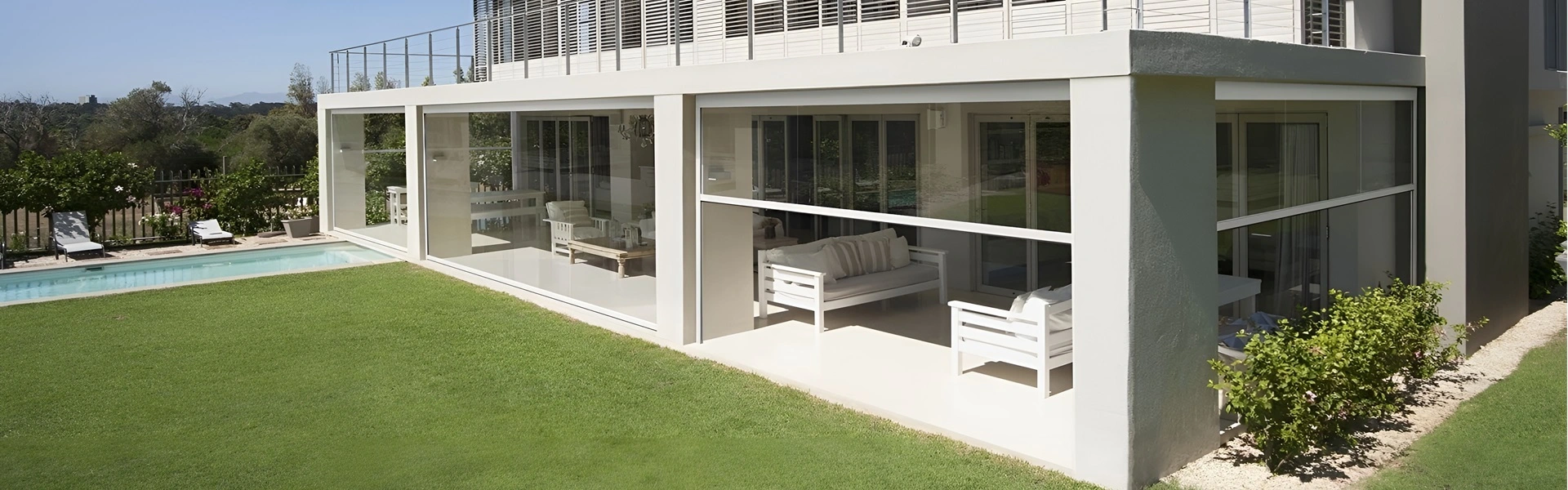 Veranda met pvc doeken, glazen wanden en witte meubels, naast een zwembad (1)