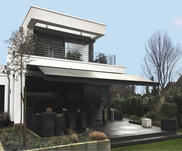 Wit huis met een zonnescherm boven het terras Wit huis met een zonnescherm boven het terras