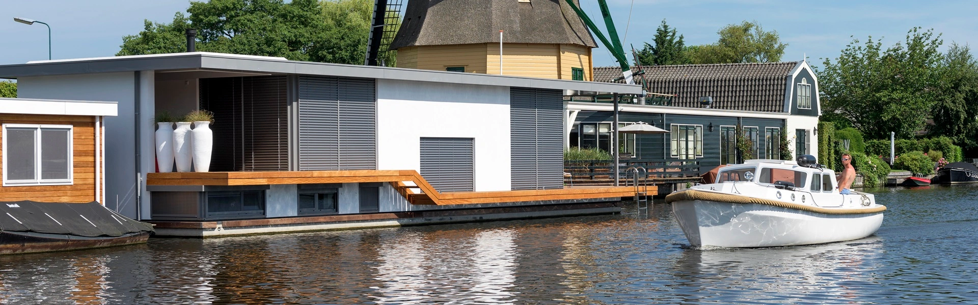 Woonboot met jaloezieen en een passerende boot