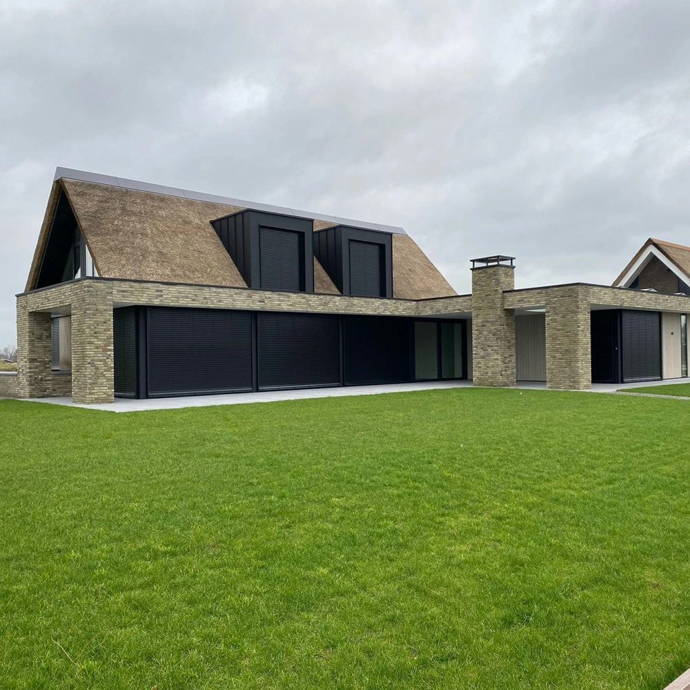 Buitenjaloezie raffstore bij woning met rieten dak Buitenjaloezie raffstore bij woning met rieten dak