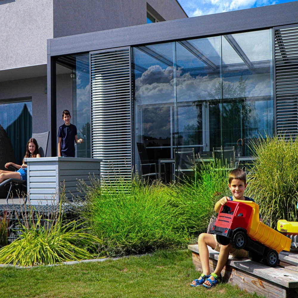 Glazen tuinkamer Cubo met kind dat buiten speelt