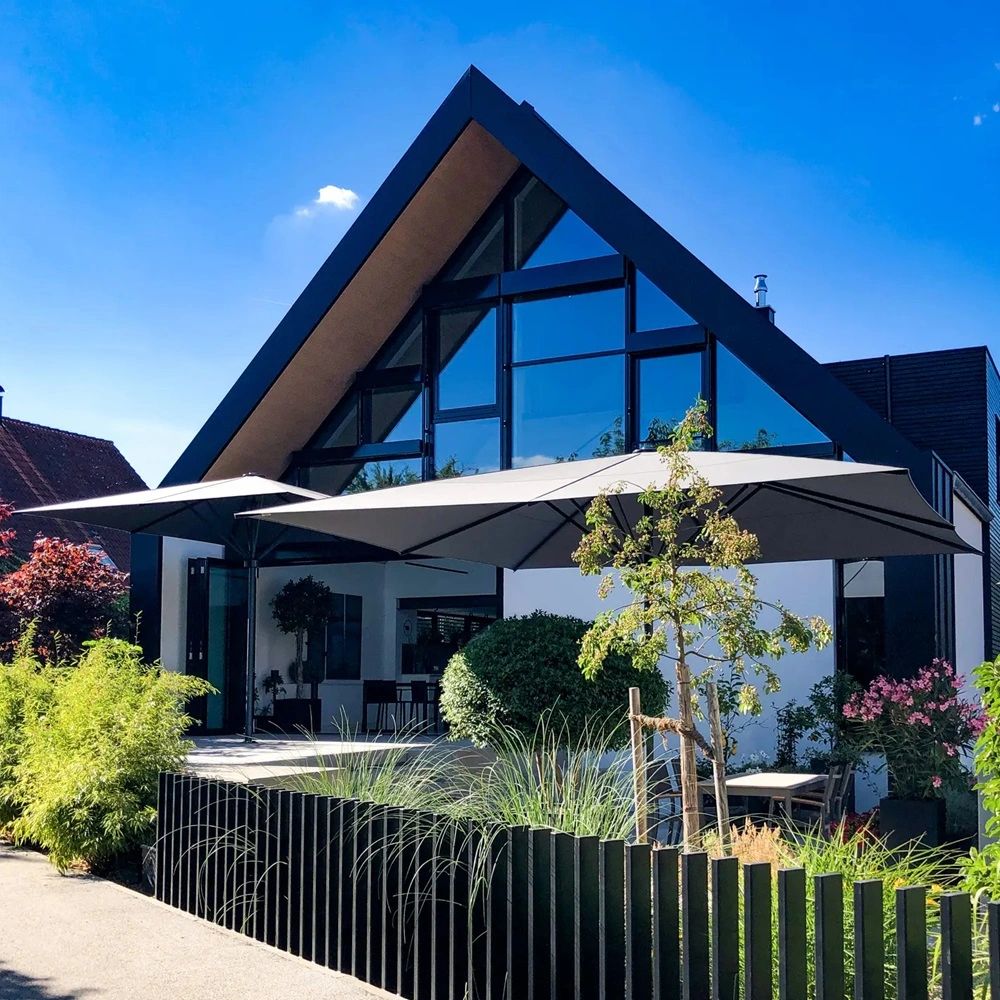 Parasol Schatello op terras bij modern huis met glazen gevel