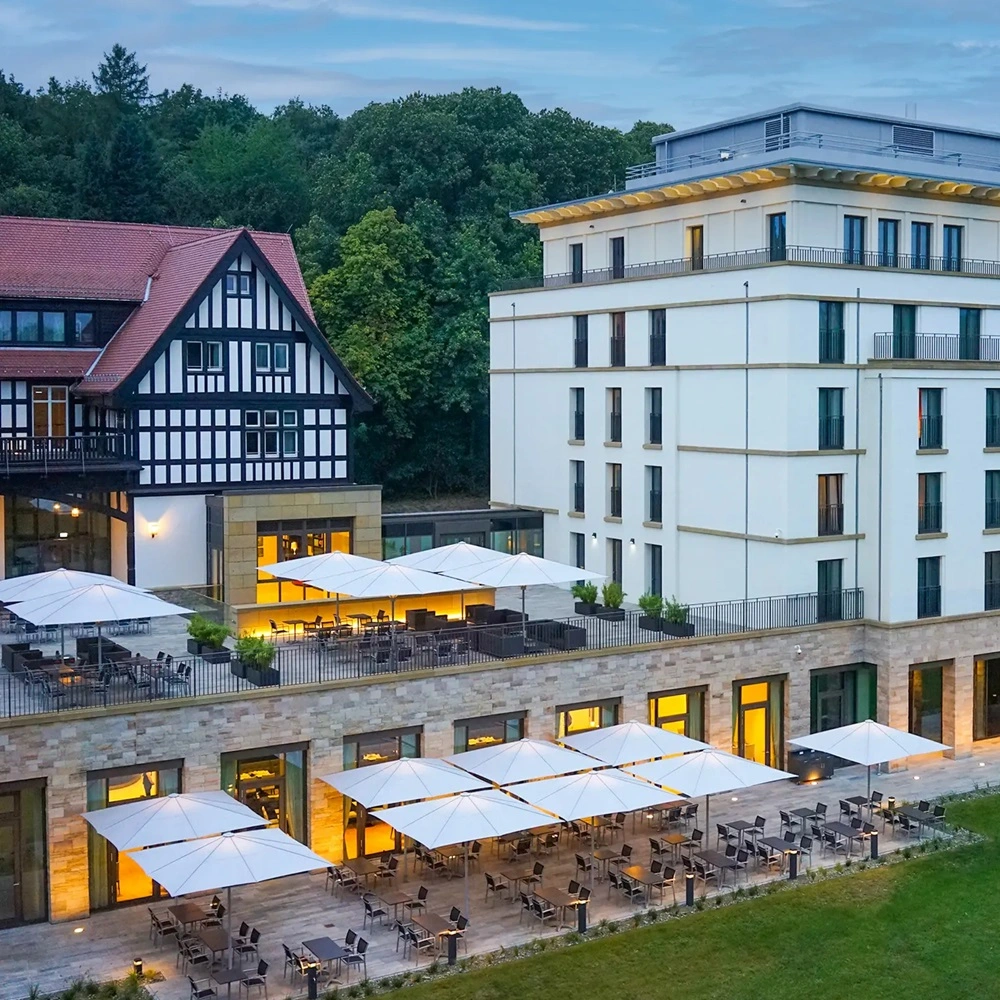 Parasol Schatello op terras van luxe hotel bij zonsondergang