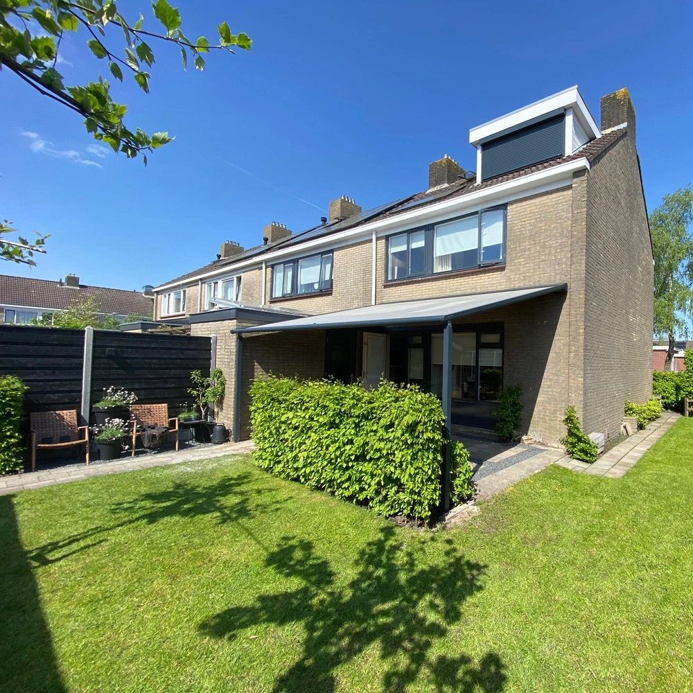 Plaza Viva met textiel doek bij een rijtjeshuis met groene heg