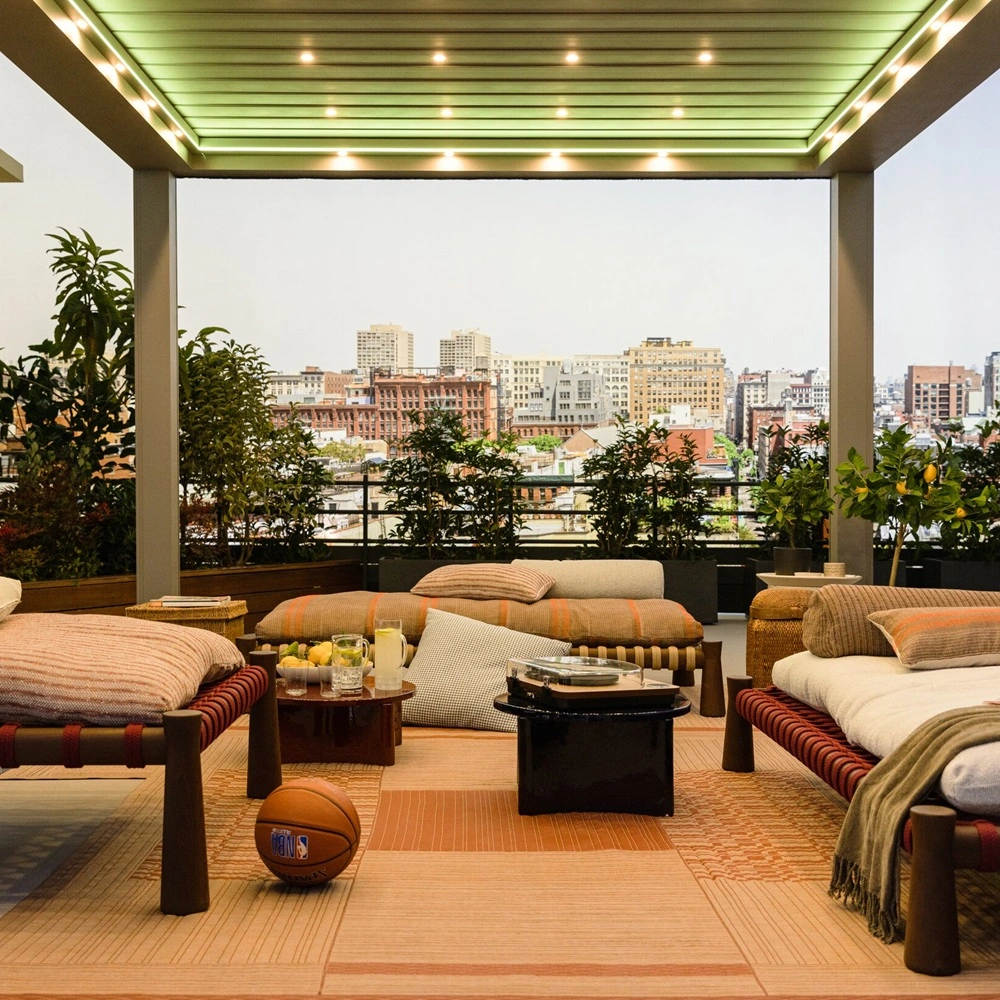 Verlicht terras met uitschuifbare Velvet Plus overkapping en uitzicht op een stad