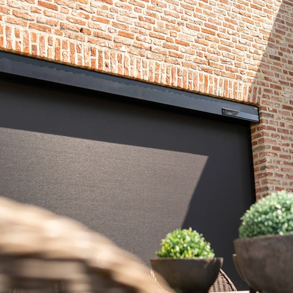Close-up van Cool screen Solar zonwering op bakstenen gevel met tuintafel