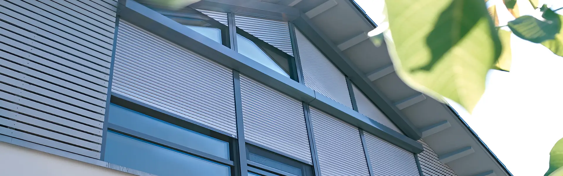 Close-up van solar rolluiken op schuin dak met ramen en glazen gevel