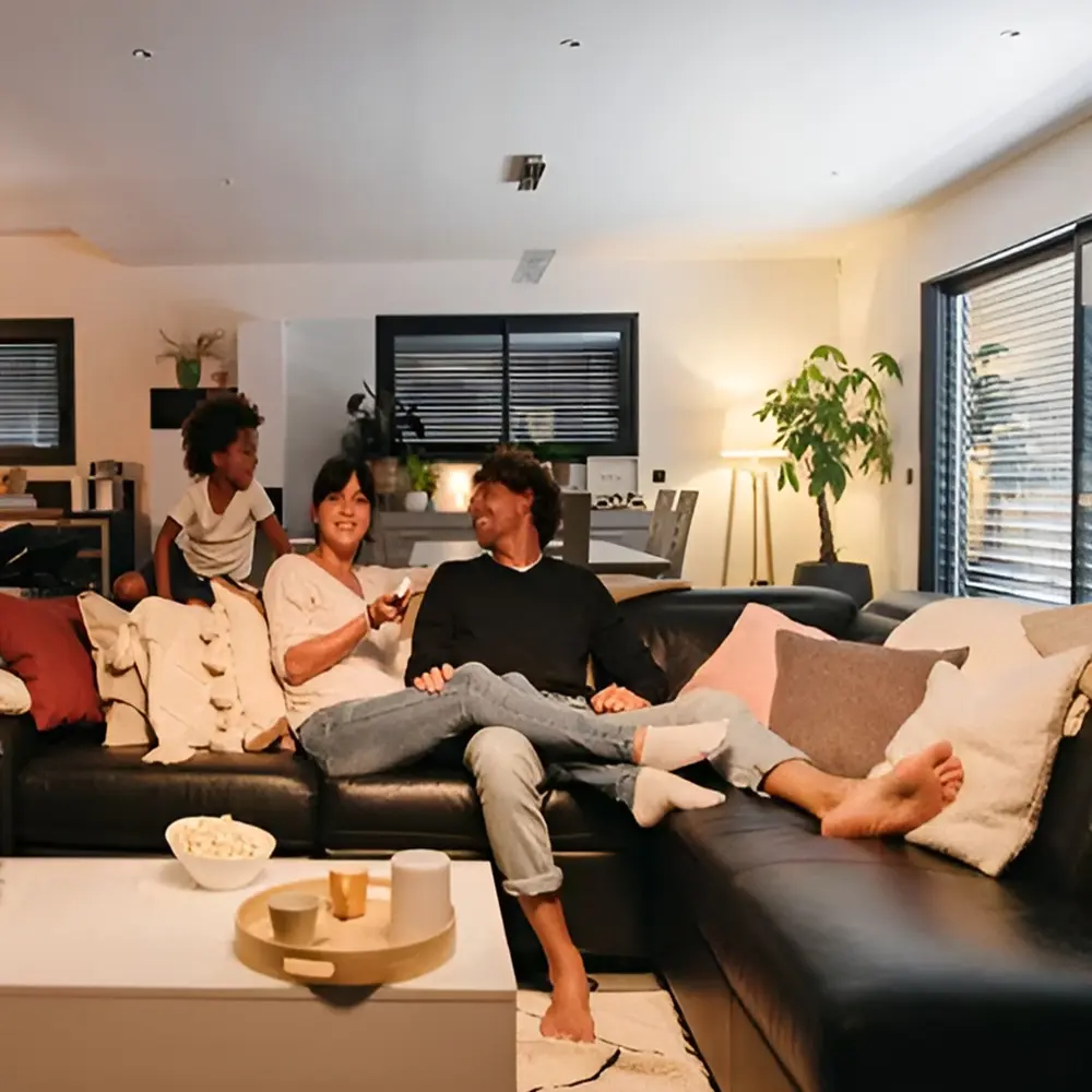 Gezin ontspant in woonkamer met elektrische rolluiken