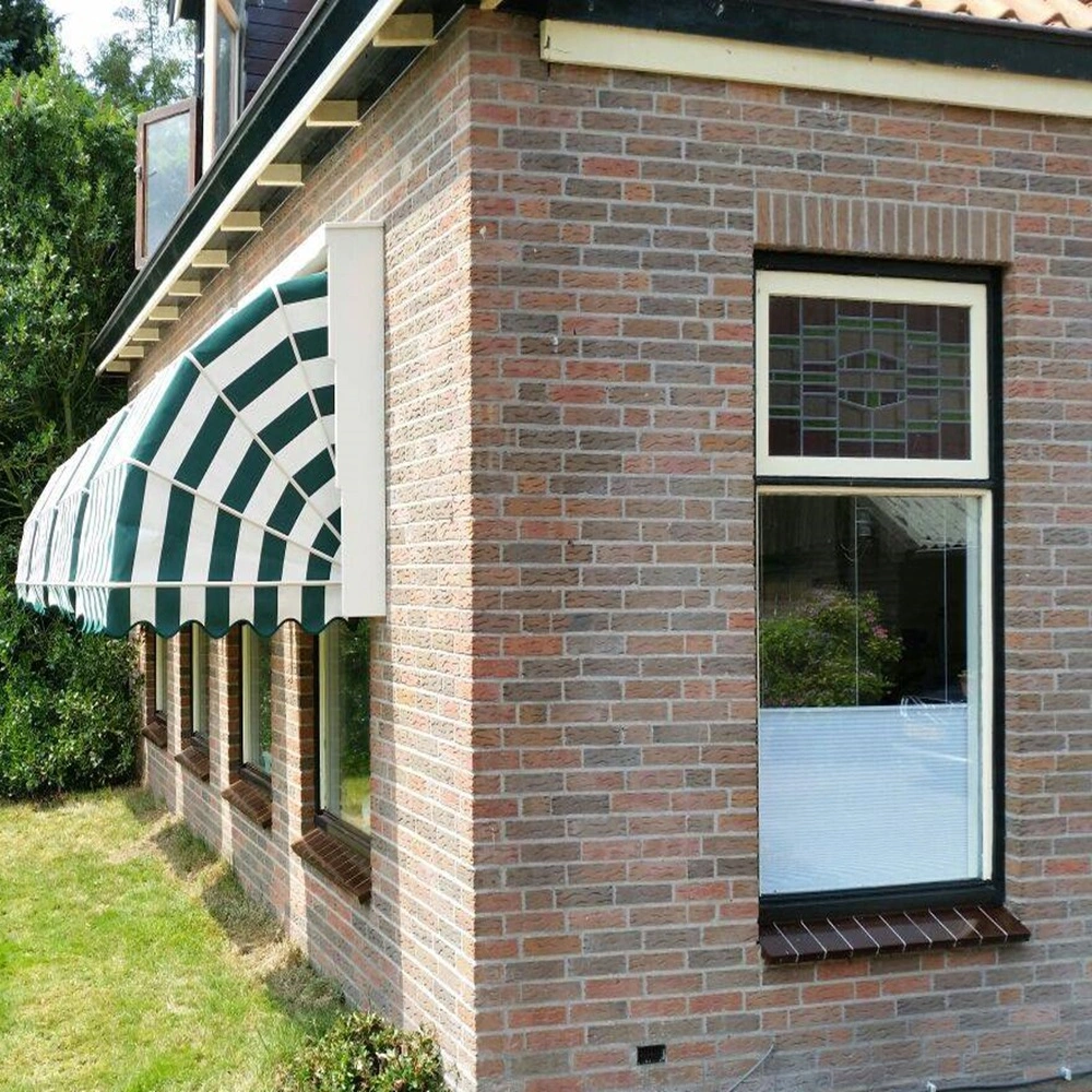 Groen-witte gestreepte markiezen boven ramen op een bakstenen huis