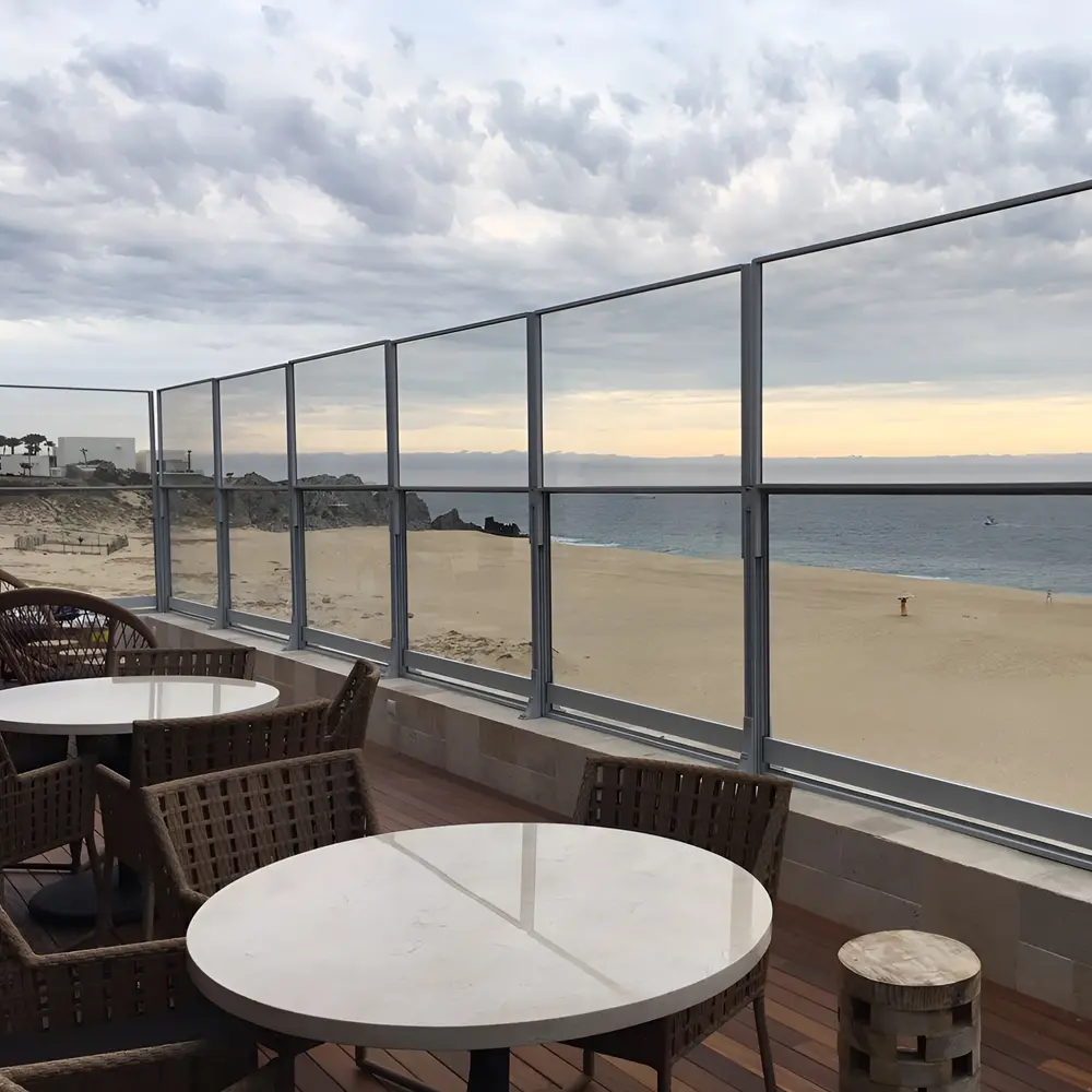 Habitat Win windscherm bij strandterras met uitzicht op de oceaan en houten meubels