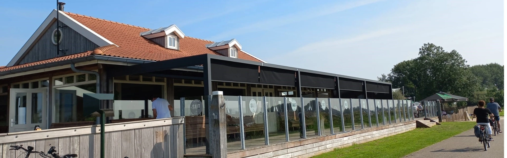 Horeca terras met glazen windscherm en zwart zonnescherm