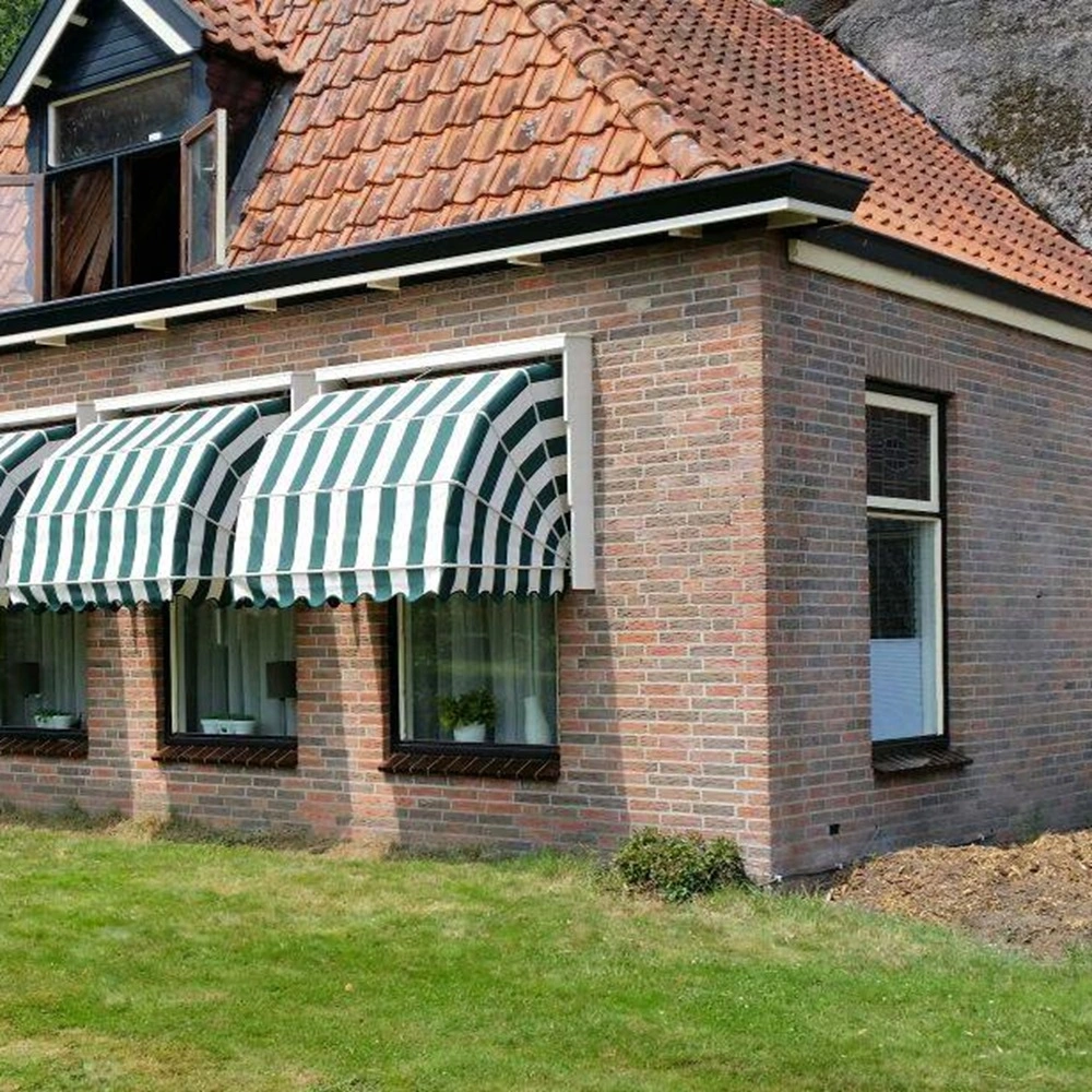 Houten markies met strepen in groen en wit op bakstenen woning met vier ramen