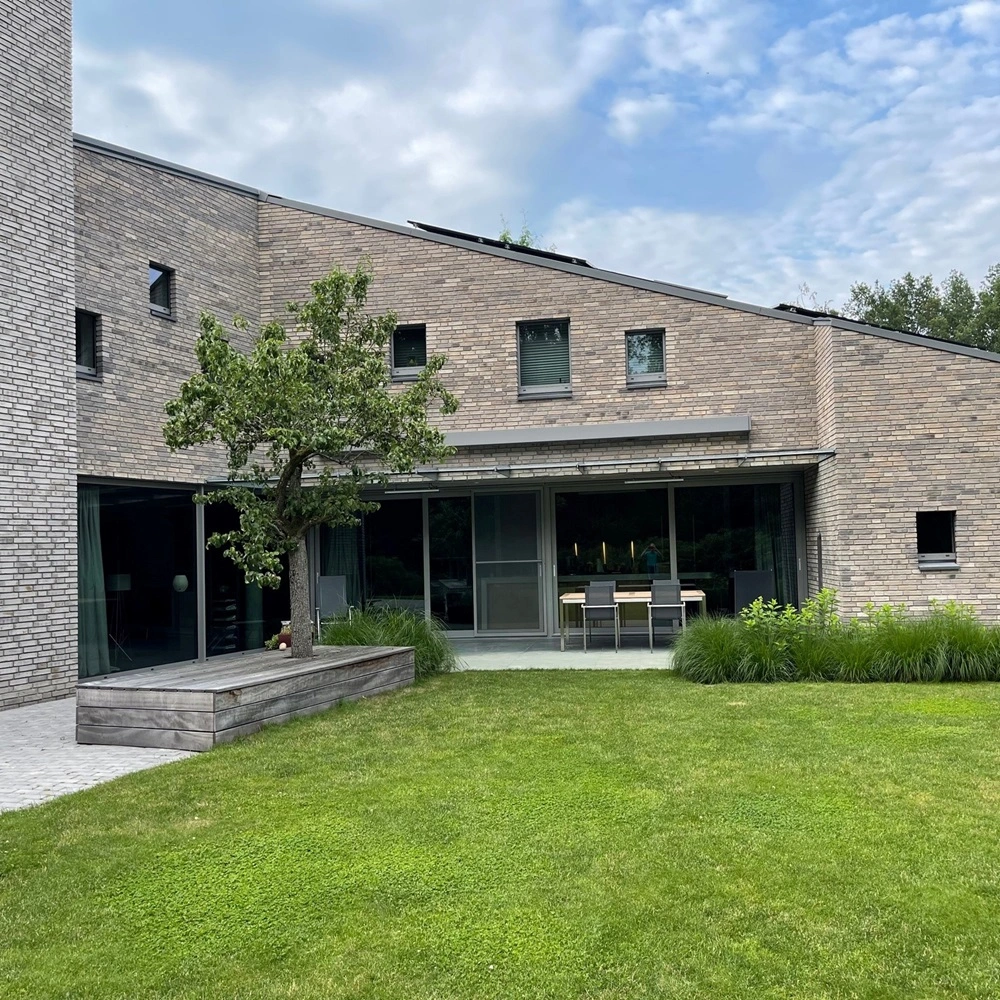 Kubata zonnescherm bij moderne woning met tuin