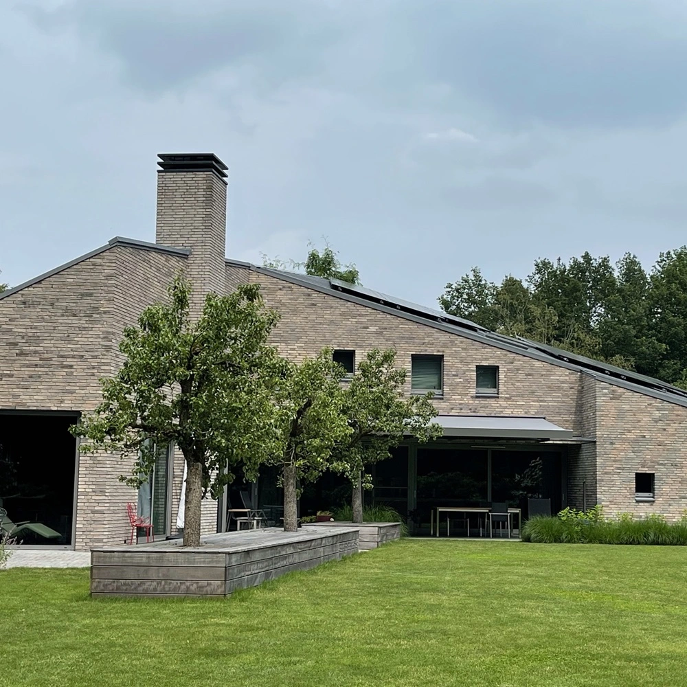 Kubata zonnescherm op stenen huis met tuin