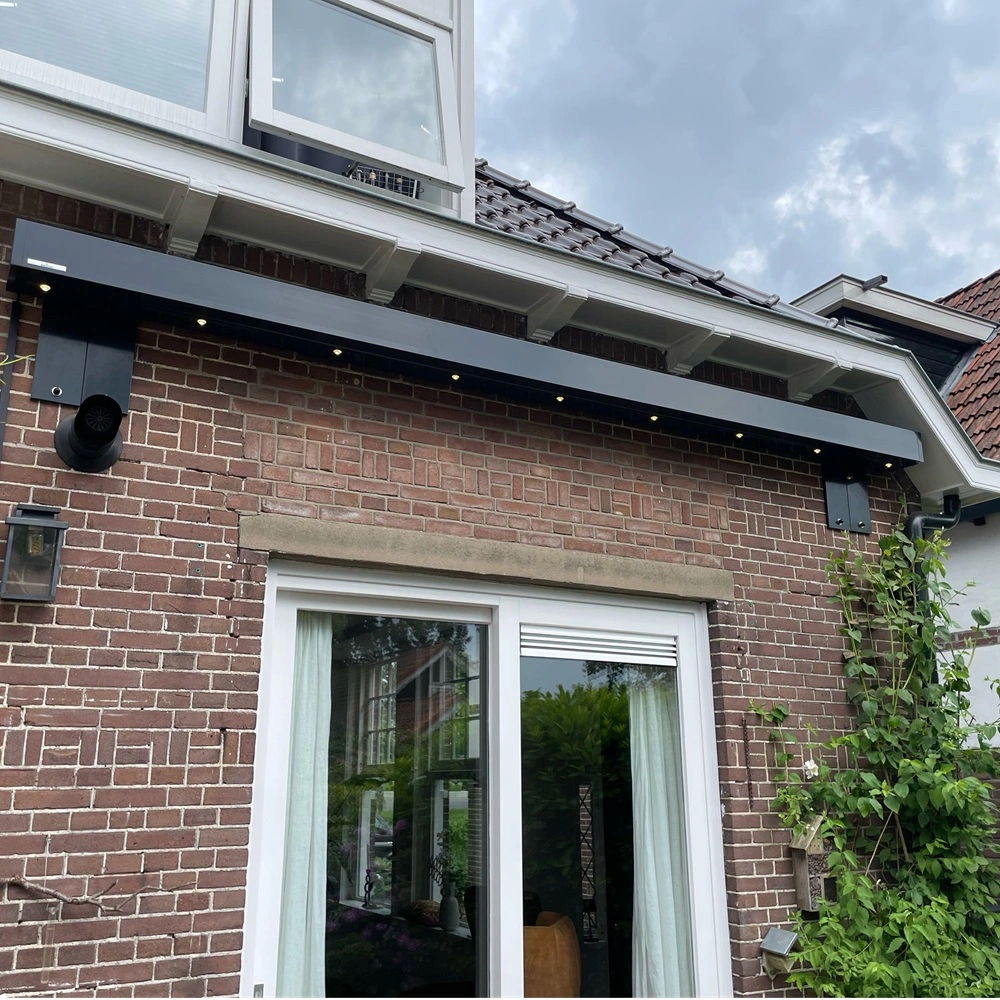 Lichtlijsten onder zonnescherm aan bakstenen gevel van huis