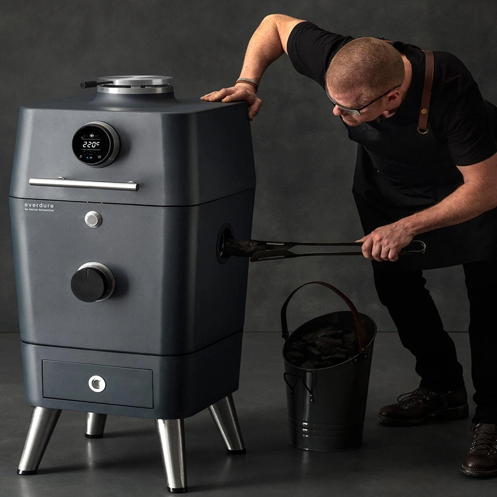 Man vult Everdure BBQ met houtskool