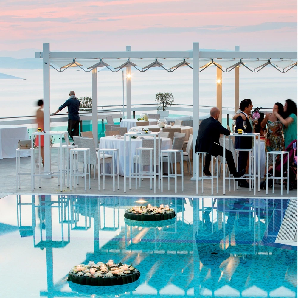 Overkapping Isola Fly bij zwembad met zitgedeelte en tafels