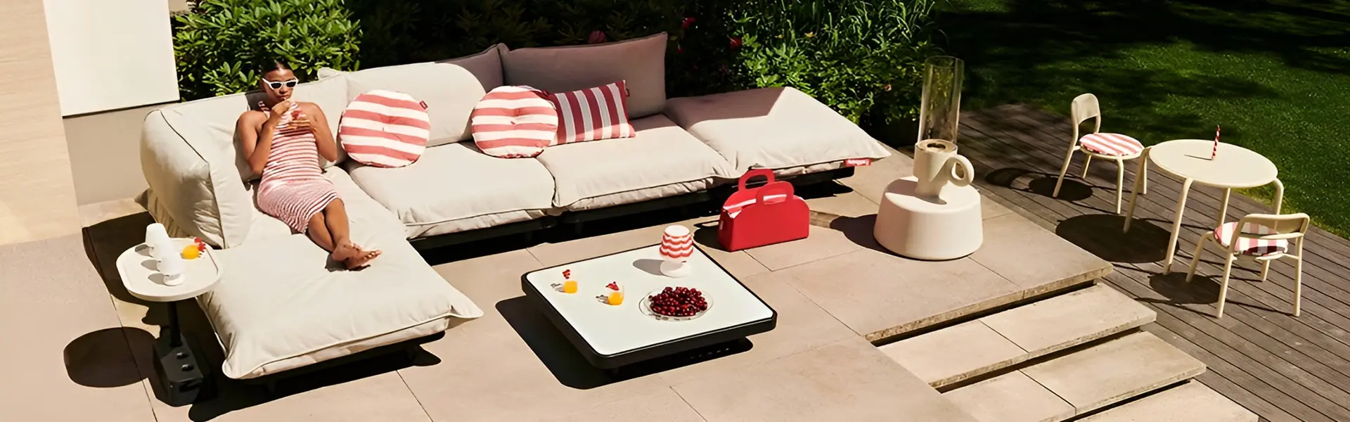 Persoon ontspannen op Fatboy Paletti loungeset met roze kussens