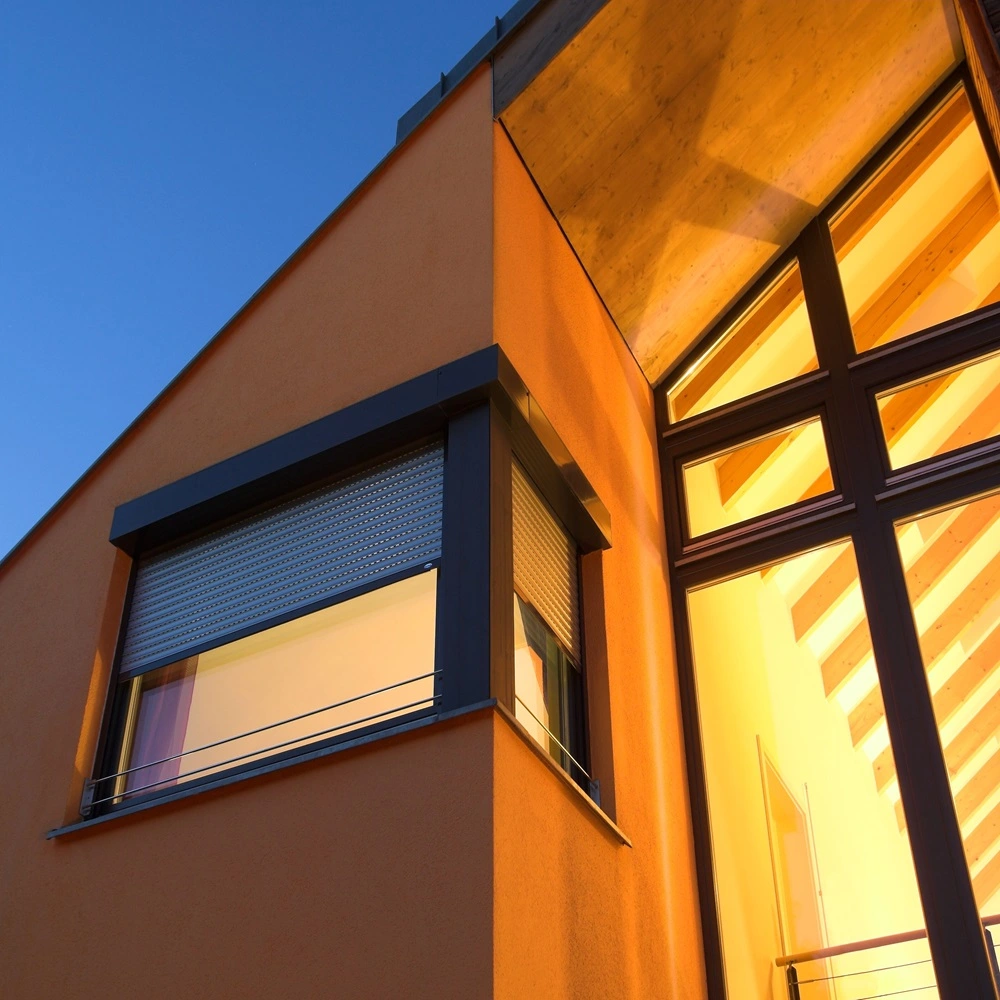 Rolluik op een oranje gevel, stijlvol gemonteerd boven raam