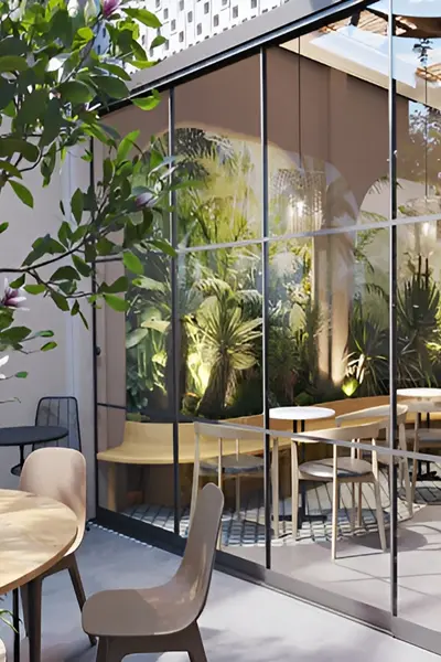 Seeglass Run glazenschuifwand in restaurant met planten en houten tafels Seeglass Run glazenschuifwand in restaurant met planten en houten tafels