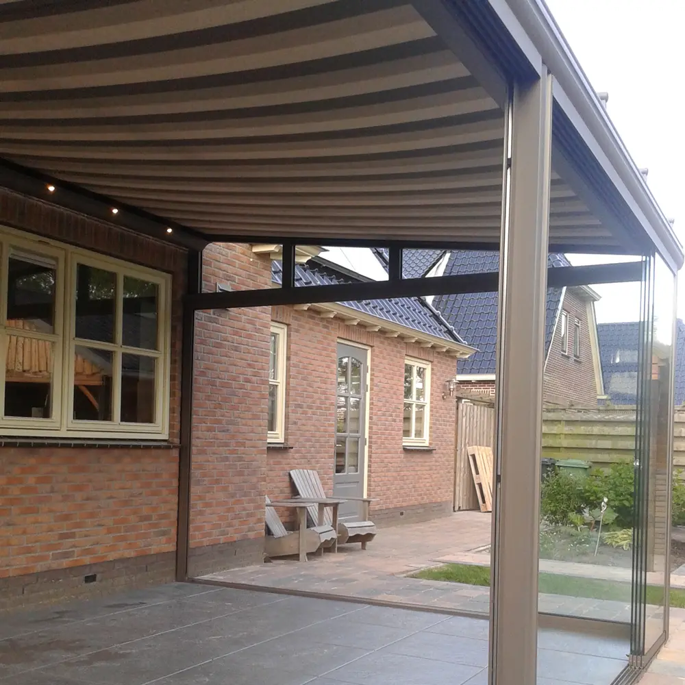 Serrezonwering Sottezza onder glazen terrasoverkapping in achtertuin met glazen schuifwand