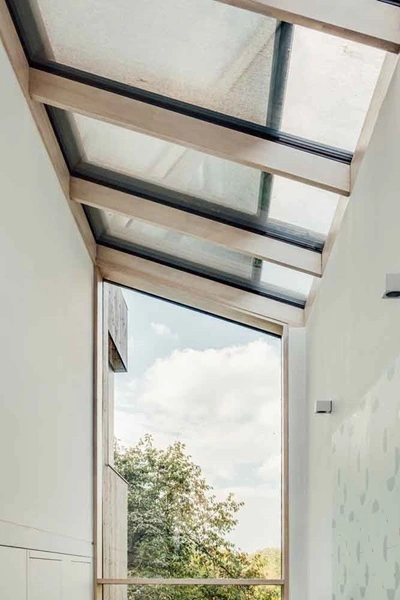 Serrezonwering VZ 720 bij glazen dak met uitzicht op bomen Serrezonwering VZ 720 bij glazen dak met uitzicht op bomen