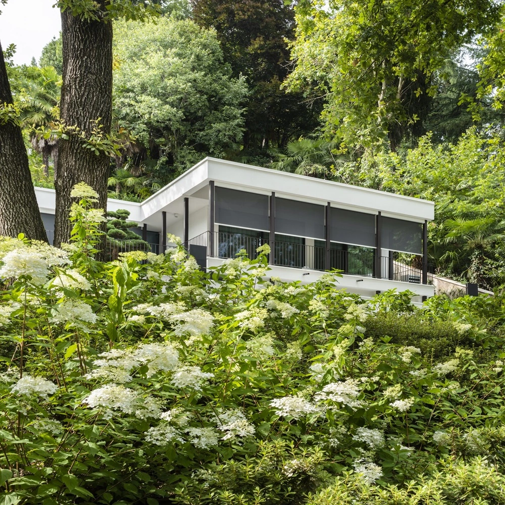 Solar Click Cable zonwering op modern huis omgeven door groen