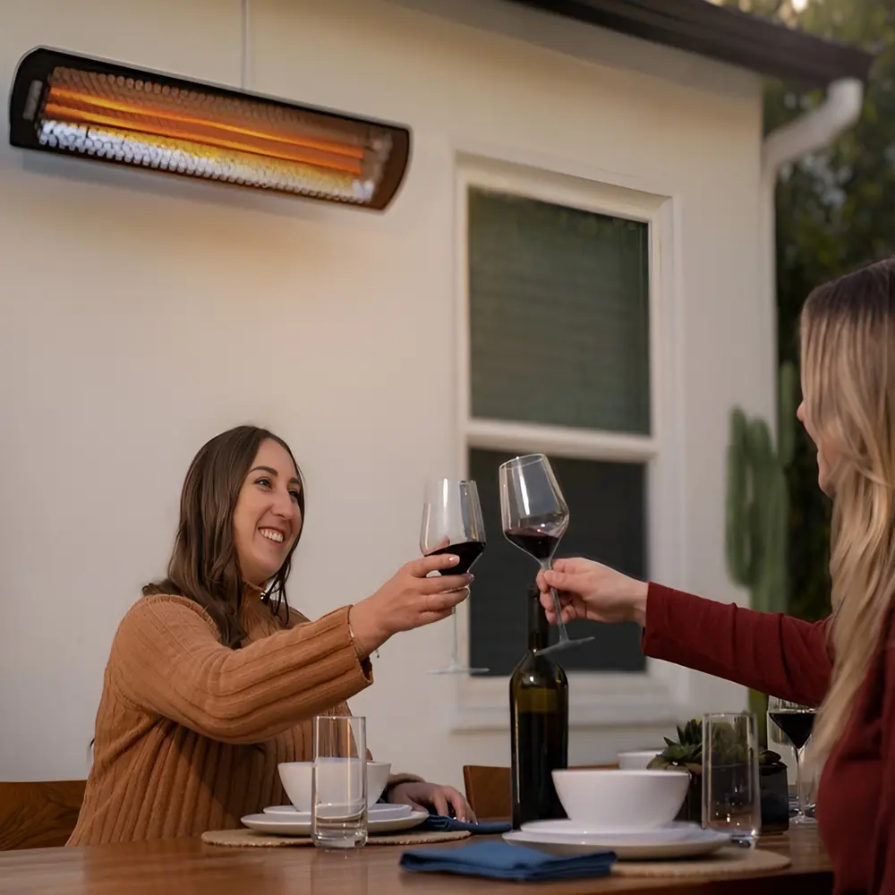 Tungsten Smart-Heat elektrische heater boven eettafel met twee vrouwen en wijnglazen