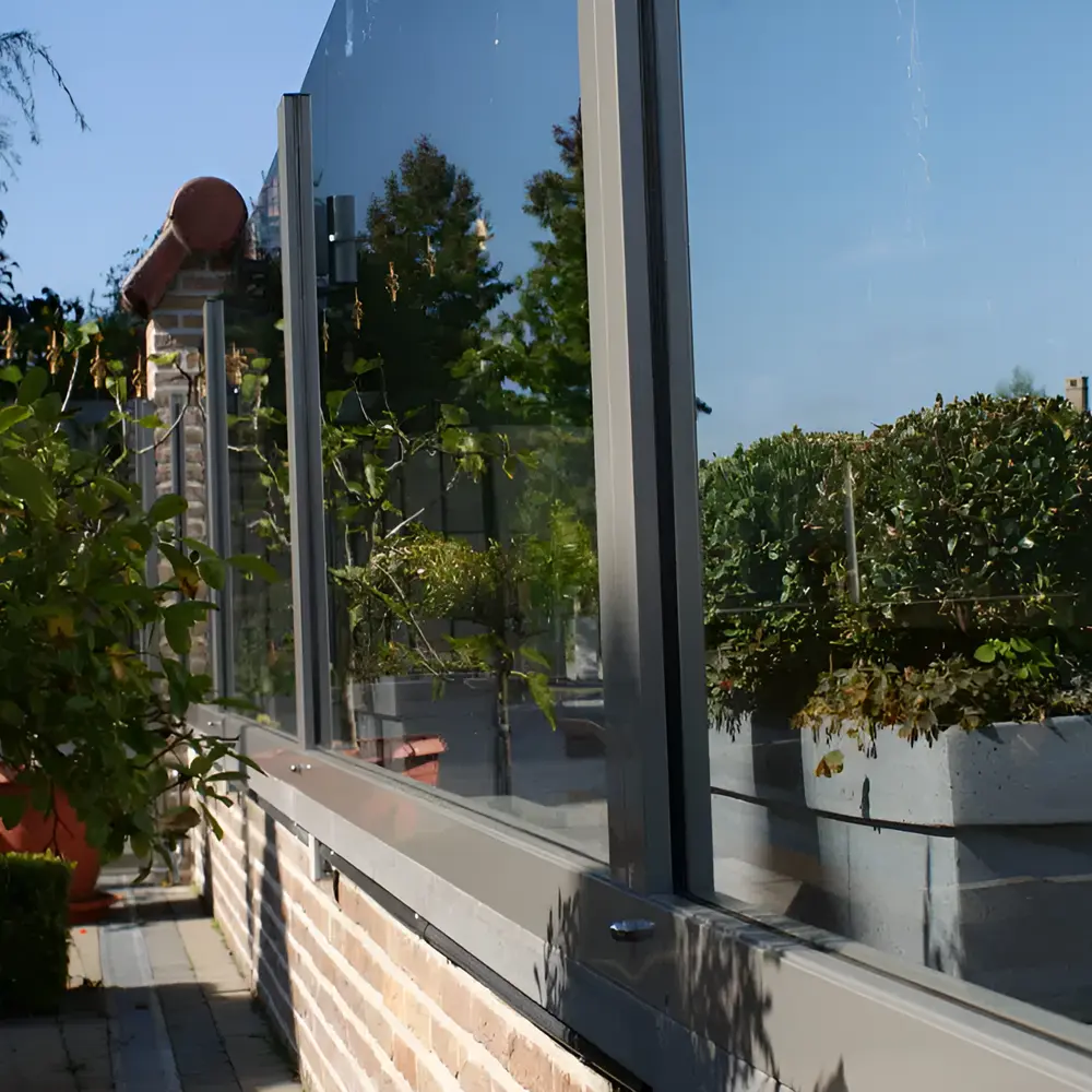 Windscherm Belles met glazen panelen en groene planten bij horecaterras