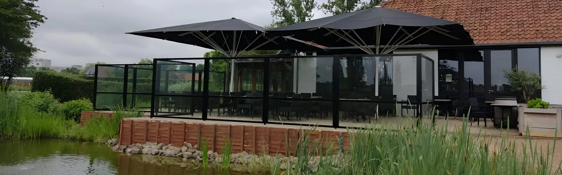 Windscherm Belles rond horecaterras met parasols aan het water