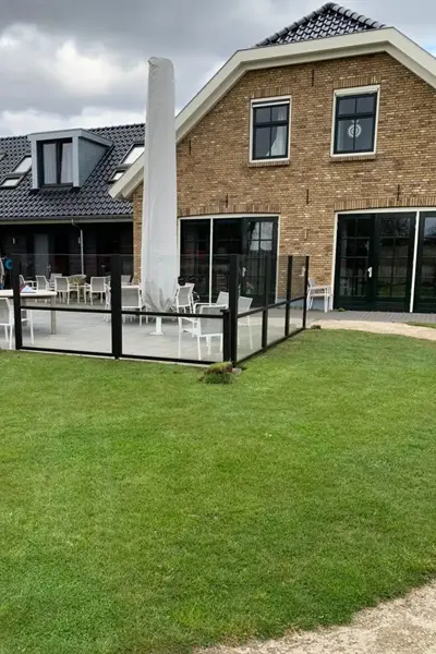 Windscherm Belles rond terras bij huis met bakstenen gevel en grote parasol Windscherm Belles rond terras bij huis met bakstenen gevel en grote parasol