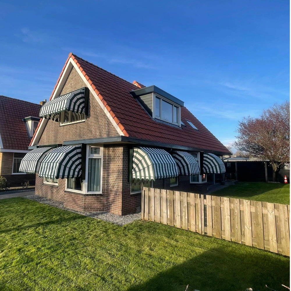 Woning met groen-witte markiezen boven ramen op een bakstenen huis