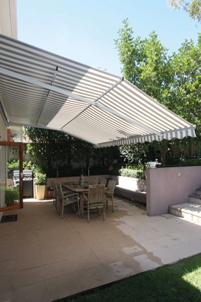 Zon en regenscherm Sunrain boven terras met tuin en eethoek Zon en regenscherm Sunrain boven terras met tuin en eethoek