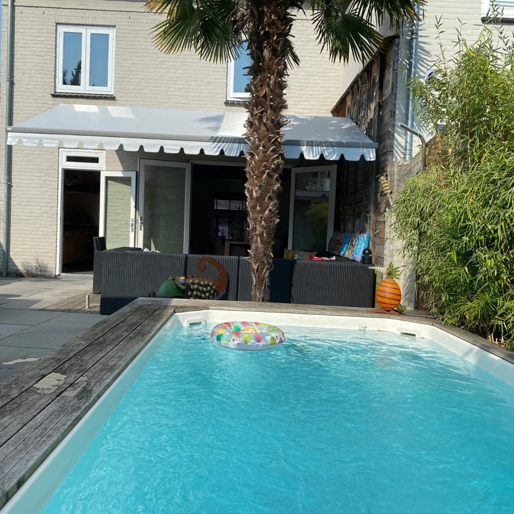 Zon en regenscherm Sunrain op terras met zithoek en zwembad