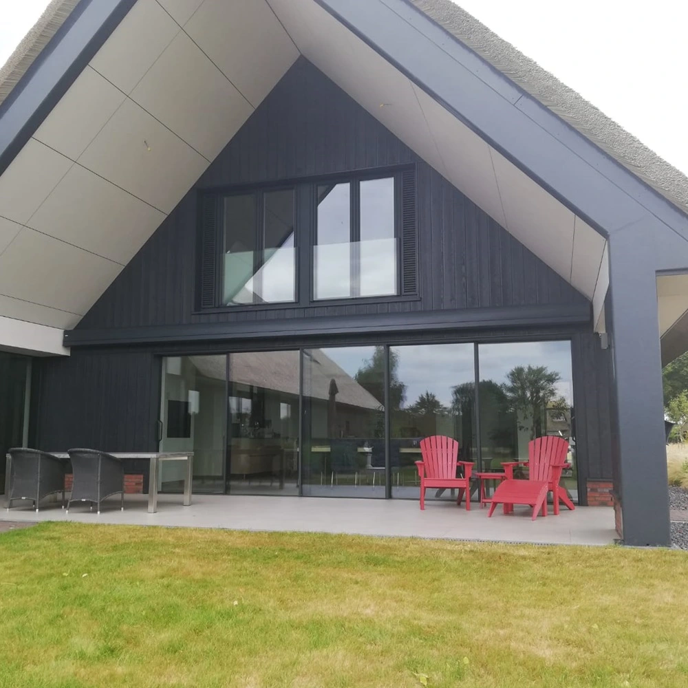 Zon en regenscherm autovolant aan woning met glazen schuifdeuren