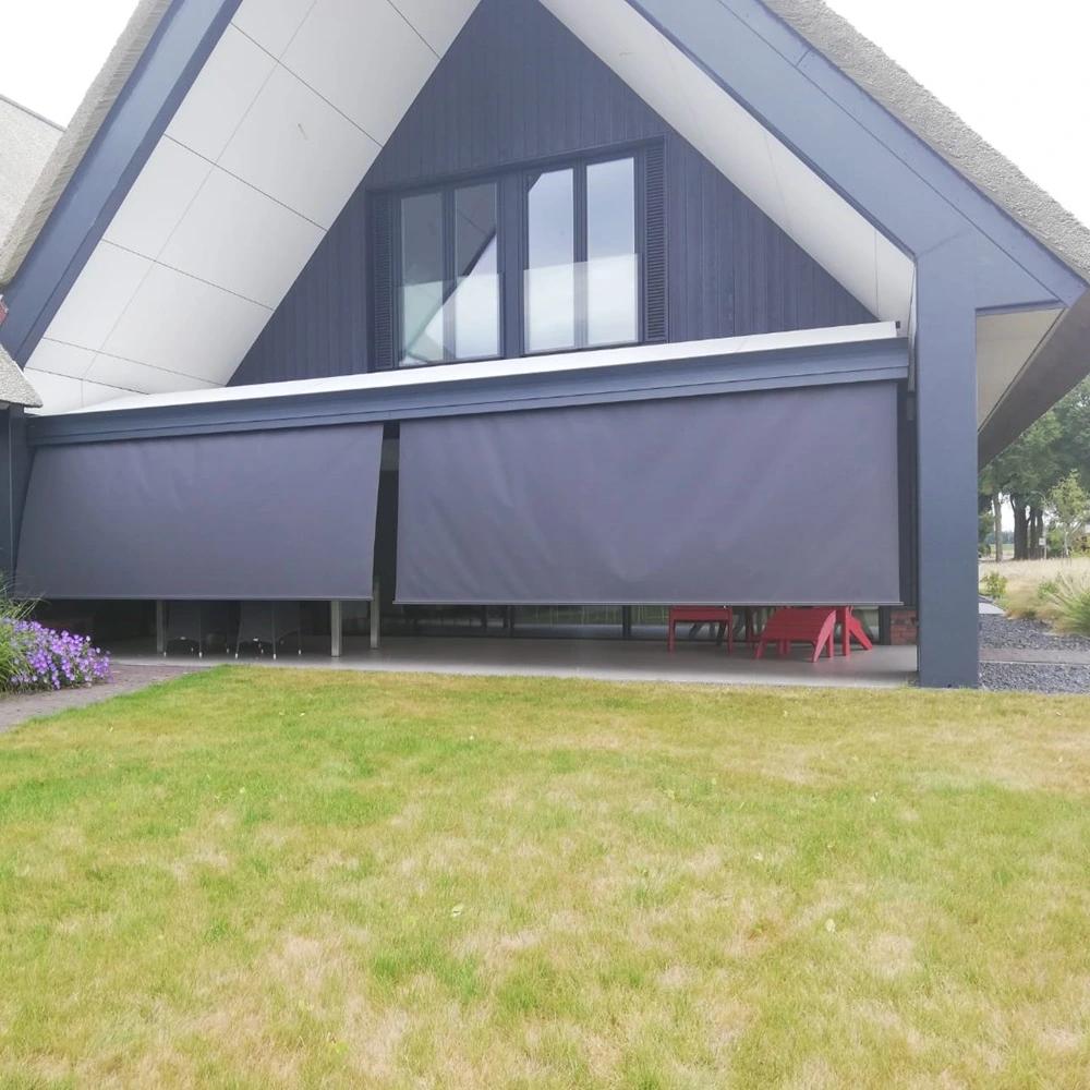 Zon en regenscherm autovolant met neergelaten schermen aan woning met tuin