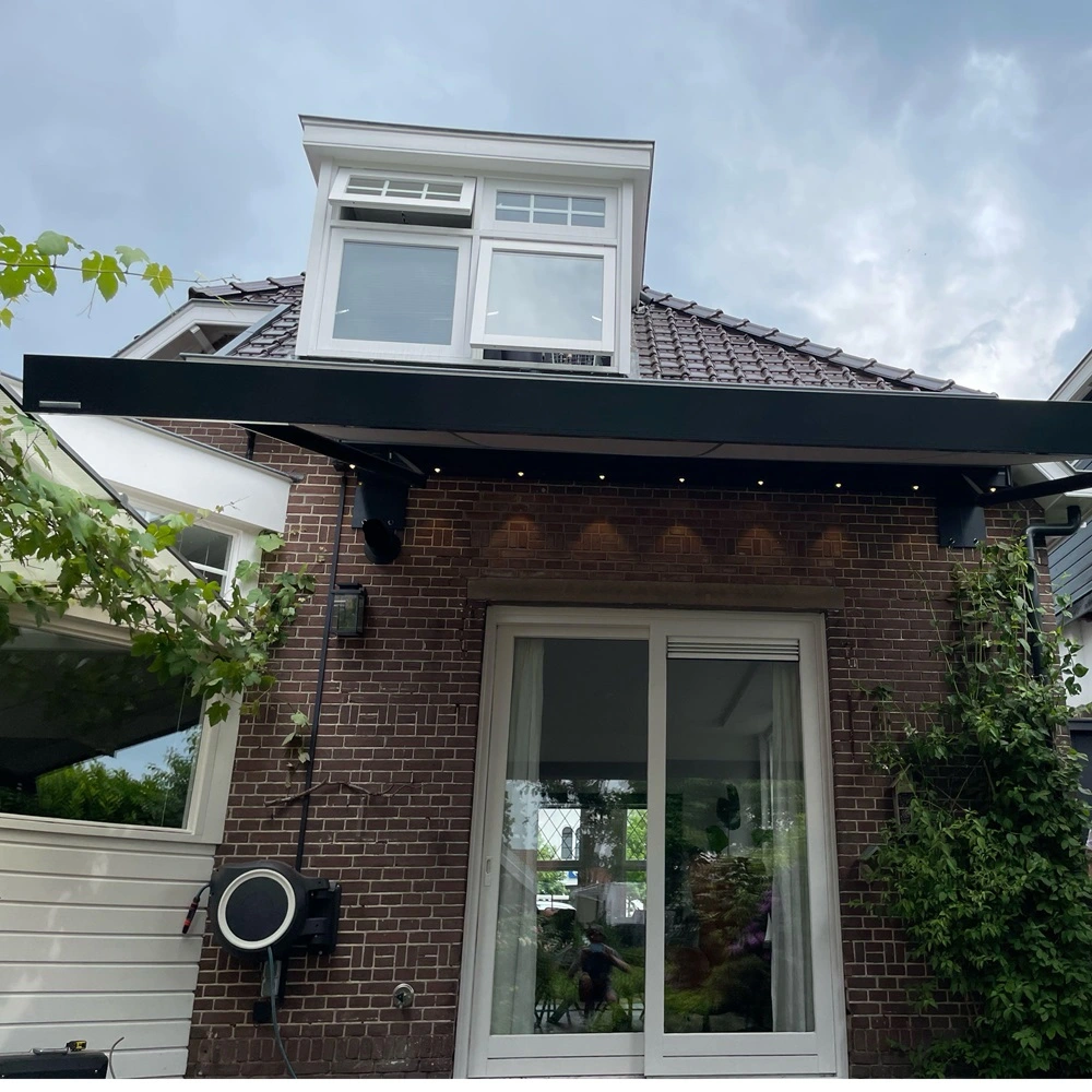 Zonnescherm met lichtlijsten boven terras bij huis met bakstenen gevel