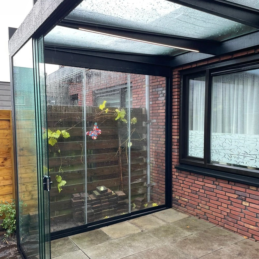 Glazen tuinkamer Terrazza Pure met open schuifdeur en regendruppels op het dak