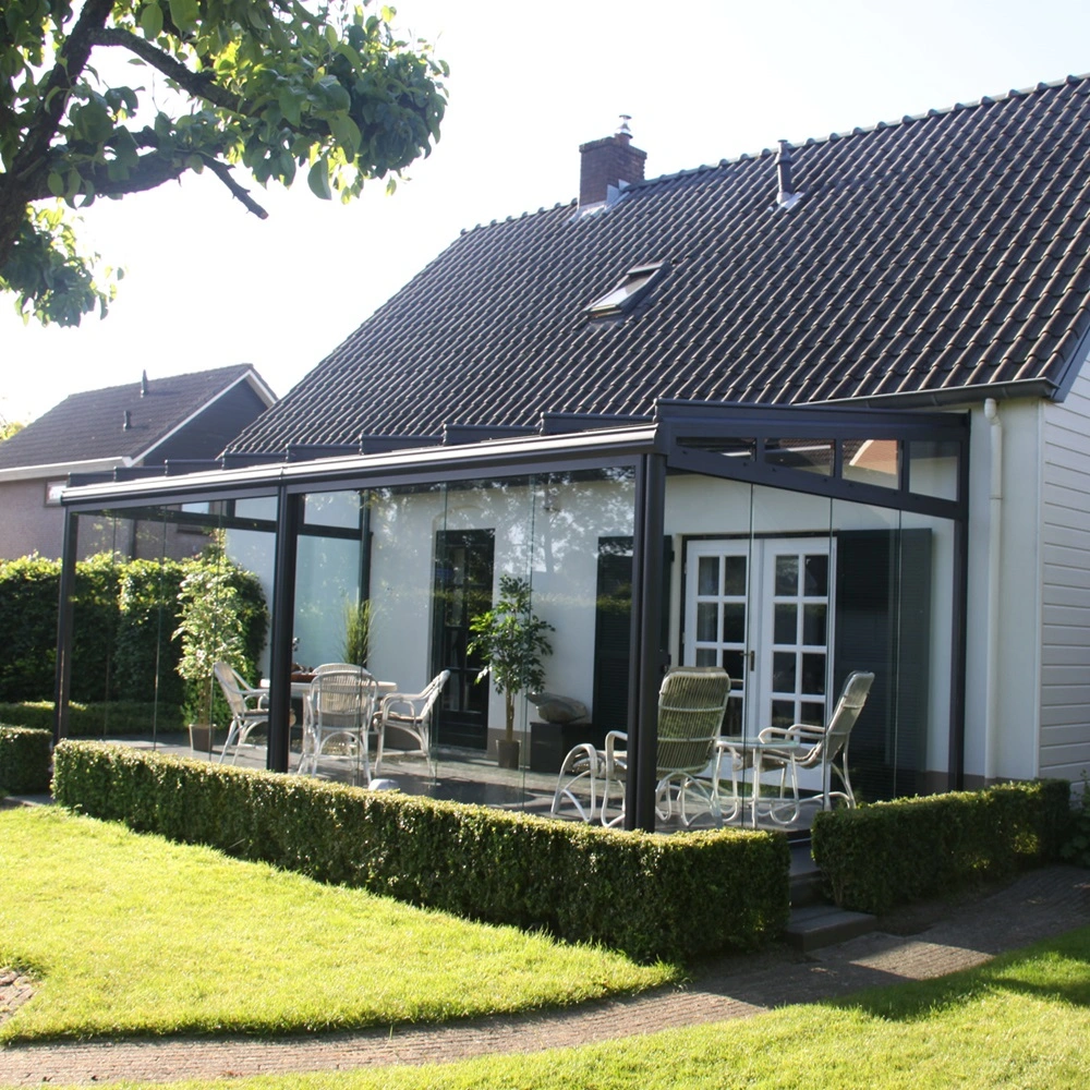 Glazen tuinkamer Terrazza Sempra met tuinmeubilair en groene hagen Glazen tuinkamer Terrazza Sempra met tuinmeubilair en groene hagen