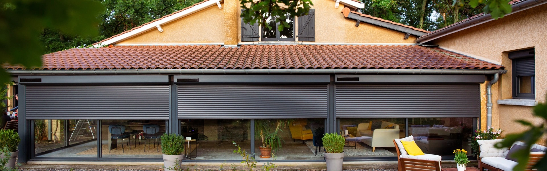 Grote zwarte solar rolluiken op glazen schuifdeuren