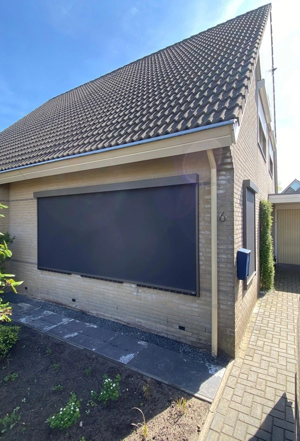 Installatie van groot Zip screen aan de zijgevel van een woning in Heerenveen Installatie van groot Zip screen aan de zijgevel van een woning in Heerenveen
