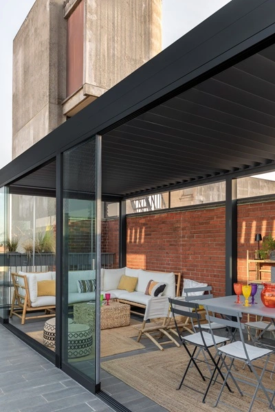 Lamellen tuinkamer Joy met glazen schuifwanden en gezellige zithoek Lamellen tuinkamer Joy met glazen schuifwanden en gezellige zithoek